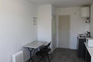 a small kitchen with a table and two chairs at Etablissements Coulon - Talence (Chemin d'Ars) in Talence