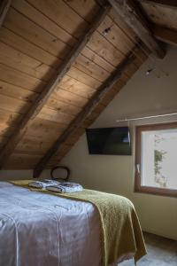 Zimmer mit einem Bett im Dachgeschoss mit einem Fenster in der Unterkunft Le Paysan Horloger in Les Bois