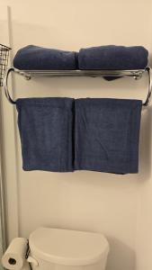 four towels are hanging above a toilet in a bathroom at Niagara Escape Crib: 3km from NiagaraFalls in Niagara Falls