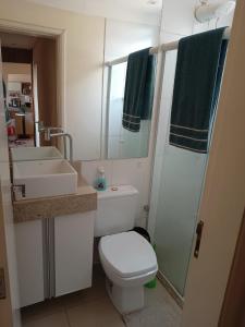 uma casa de banho com um WC, um lavatório e um espelho. em Quarto suíte represa centro, ape compartilhado em São José do Rio Preto