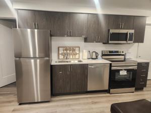 a kitchen with wooden cabinets and a stainless steel refrigerator at Niagara Escape Crib: 3km from NiagaraFalls in Niagara Falls