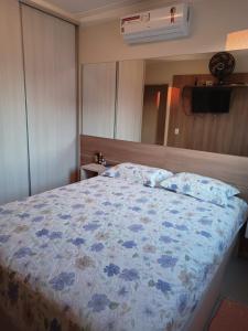 um quarto com uma cama com flores azuis em Quarto suíte represa centro, ape compartilhado em São José do Rio Preto