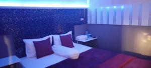 a hotel room with a bed with pillows at New KAMI Homestay in Banyuwangi