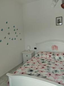 una camera da letto con un letto con fiori e farfalle di La Collina a Riccò del Golfo di Spezia