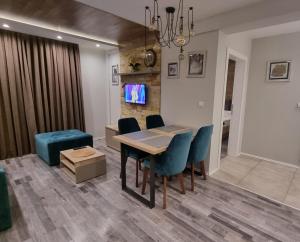 een eetkamer met een tafel en blauwe stoelen bij Apartman Premier 32 Milmari in Kopaonik