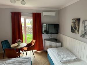Zimmer mit einem Bett, einem Tisch und einem TV in der Unterkunft Forteca, pokoje gościnne nad stawem in Dzierżoniów