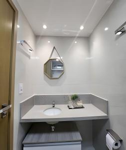 W łazience znajduje się umywalka i lustro. w obiekcie Conforto no Caminho das árvores w mieście Salvador