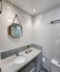a bathroom with a sink and a mirror on the wall at Conforto no Caminho das árvores in Salvador