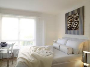 un soggiorno bianco con letto e tavolo di VISIONAPARTMENTS Chemin des Epinettes - contactless check-in a Losanna
