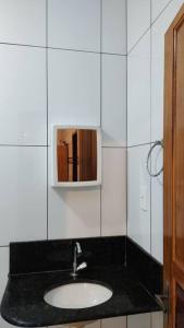uma casa de banho com um lavatório e um espelho em Acomodação paraju-apartamento em caratinga em Caratinga