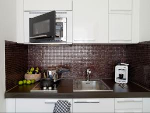 a kitchen with a sink and a microwave at VISIONAPARTMENTS Chemin des Epinettes - contactless check-in in Lausanne