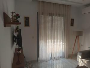 een woonkamer met een raam met witte gordijnen bij VIP Tunisia in La Goulette