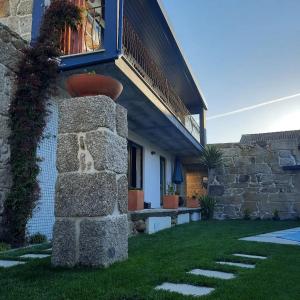 a house with a flower pot on the side of it at Casa do Abade - Country House in Viseu