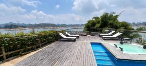 una terrazza con sedie e una piscina accanto a un fiume di MURAT HOTEL a Guatapé