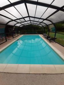 una gran piscina con techo alto en lamaisonmelidine en Saint-Mards-de-Blacarville
