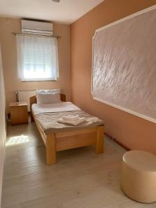 a small bedroom with a bed and a window at Sobe Sara in Šabac