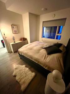 a bedroom with a bed and a window and a rug at Modern luxury apt downtown in Reykjavík