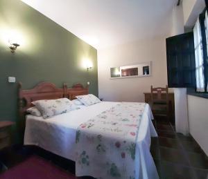 a bedroom with a bed with a white comforter at La Casa Solariega in Santillana del Mar