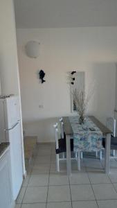 a kitchen with a table and a table and chairs at Sardegna Casa Ruby Baia de bahas Marinella in Santa Marinella