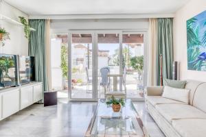 a living room with a couch and a glass table at Hanami Alcazaba Beach Duplex Sea View in Estepona