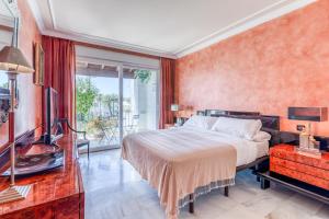 a bedroom with a large bed and a tv at Hanami Alcazaba Beach Duplex Sea View in Estepona +33 photos