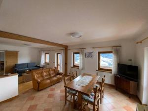 ein Wohnzimmer mit einem Tisch und einem Sofa in der Unterkunft Appartamento da Fabio - nel cuore delle Dolomiti in Danta