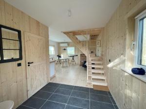 a room with a wooden wall with a staircase and a table at Astroturystyka Izeria in Leśna +51 photos