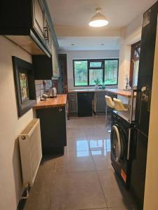 a kitchen with a washing machine in the middle of it at Quiet family home in Tettenhall
