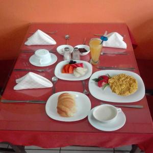 a red table with plates of food on it at Hotel El Ejido in Quito