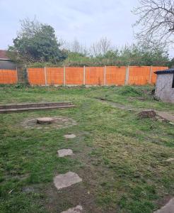 an empty field with an orange fence in the background at Quiet family home in Tettenhall