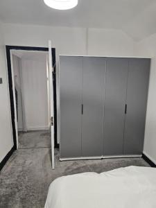 a bedroom with white cabinets and a bed in it at Quiet family home in Tettenhall