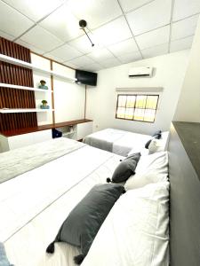 Duas camas num quarto com paredes brancas em Cozy Cabin in Santa Tecla, 25 mins from surf city em Nueva San Salvador