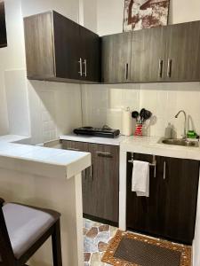 uma cozinha com armários de madeira e um lavatório em Cozy Cabin in Santa Tecla, 25 mins from surf city em Nueva San Salvador