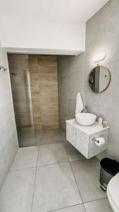 普羅塔拉斯的住宿－WAKE UP BY THE SEA FLATS，一间带水槽和镜子的浴室