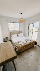 a bedroom with a large bed and a table at WAKE UP BY THE SEA FLATS in Protaras