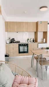 a living room with a table and a kitchen at WAKE UP BY THE SEA FLATS in Protaras