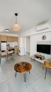 a living room with a table and a kitchen at WAKE UP BY THE SEA FLATS in Protaras