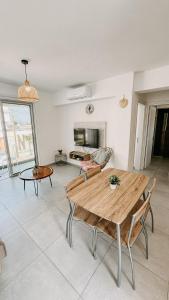 a living room with a wooden table and chairs at WAKE UP BY THE SEA FLATS in Protaras