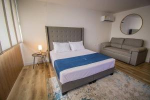 une petite chambre avec un lit et un canapé dans l'établissement TOP FLOOR Studio Poblado, A/C, Coworking, gym 1416, à Medellín