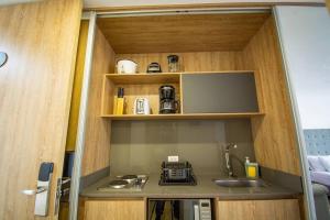 une petite cuisine avec un évier et un micro-ondes dans l'établissement TOP FLOOR Studio Poblado, A/C, Coworking, gym 1416, à Medellín
