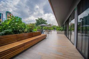 un bâtiment avec des bancs, des tables et des plantes en bois dans l'établissement TOP FLOOR Studio Poblado, A/C, Coworking, gym 1416, à Medellín