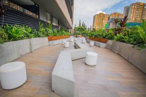 Une rangée de bancs blancs dans un bâtiment dans l'établissement TOP FLOOR Studio Poblado, A/C, Coworking, gym 1416, à Medellín