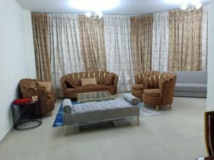 a living room with two chairs and a couch at 22 R4 Single 1 small room in a 4-bedroom apartment with attached bathroom suitable for one person ### 22 R4 1 غرفة صغيرة في شقة مكونة من 4 غرف نوم مع حمام ملحق مناسبة لشخص واحد in Ajman 
