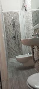 bagno con doccia, lavandino e servizi igienici di Casa vacanza dirupo a Pisticci