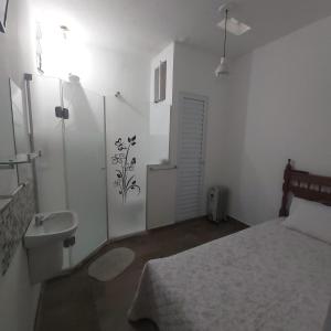 a white bedroom with a bed and a sink at Hostel Jardim da Saúde in Sao Paulo