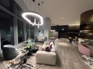メルボルンにあるWSP LUX 1B1B apartment in CBDのリビングルーム(ソファ、椅子、シャンデリア付)