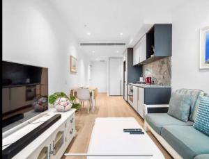メルボルンにあるWSP LUX 1B1B apartment in CBDのソファとテーブルのあるキッチンとリビングルーム
