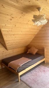 a log cabin with a bed in a room at Siedlisko Huta Szklana in Bieliny