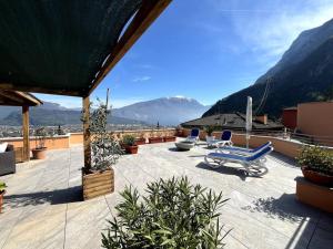 een patio met stoelen en uitzicht op de bergen bij La Terrazza - Solarium Privato 150mq Vista Lago in Riva del Garda