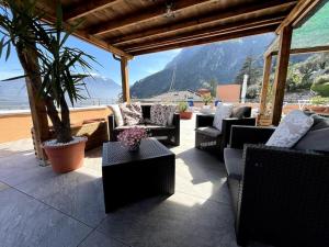 een patio met stoelen en tafels en uitzicht op de oceaan bij La Terrazza - Solarium Privato 150mq Vista Lago in Riva del Garda